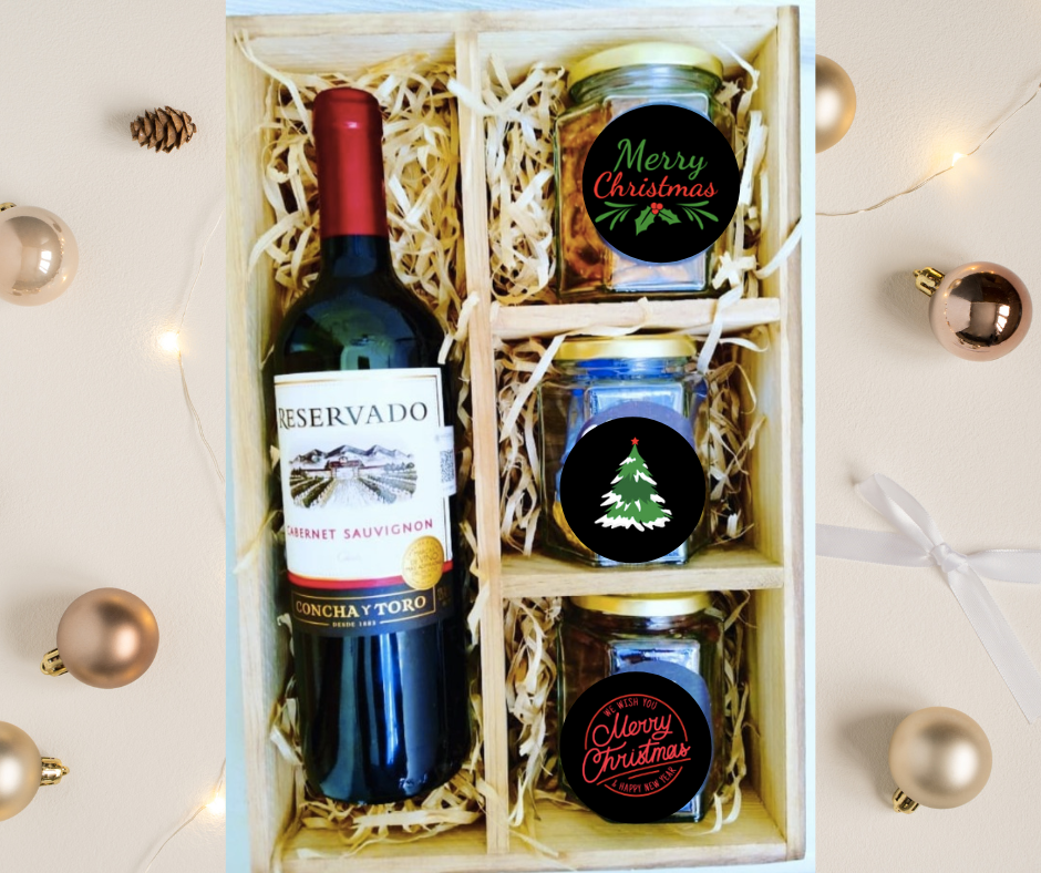 box con vino tinto chileno y frascos con pasitas con chocolate snacks y ferrero rocher